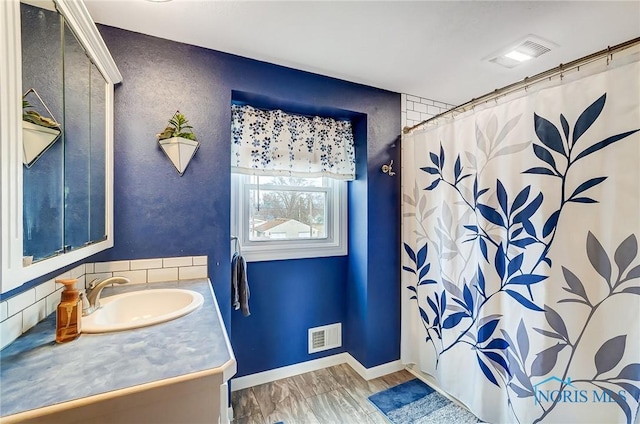 bathroom with curtained shower, visible vents, vanity, and wood finished floors