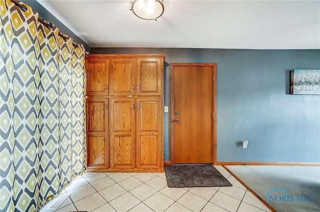 foyer entrance featuring baseboards and light tile patterned floors