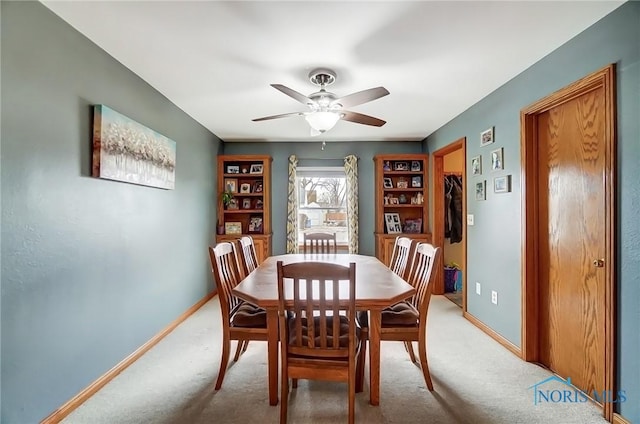 dining area with light carpet, ceiling fan, and baseboards