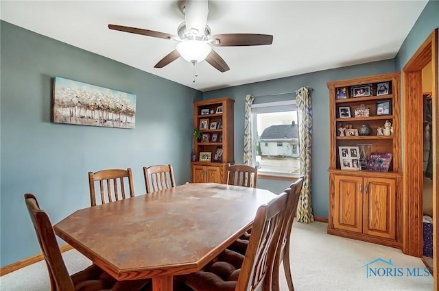 dining space featuring light carpet, ceiling fan, and baseboards