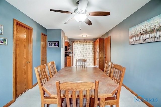 dining area with ceiling fan and baseboards