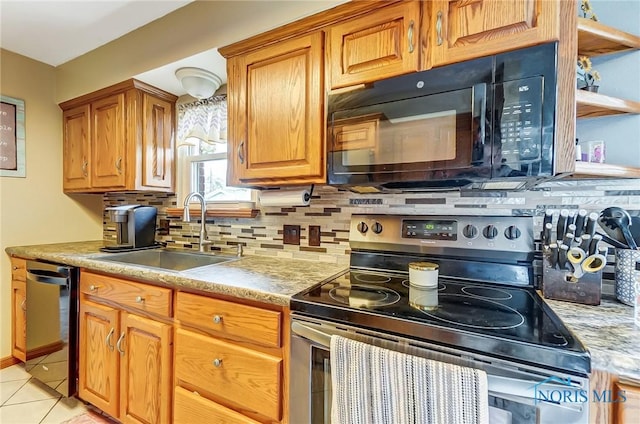 kitchen featuring light tile patterned floors, a sink, light countertops, black appliances, and backsplash