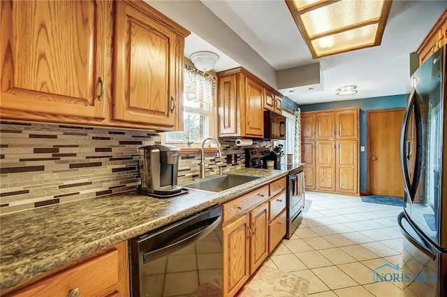 kitchen with brown cabinets, light tile patterned floors, tasteful backsplash, a sink, and black appliances