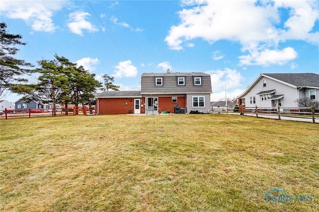 rear view of property with a yard and fence