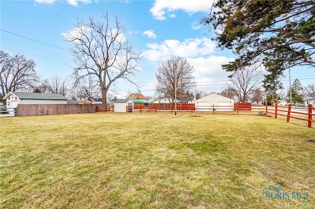 view of yard with a fenced backyard, a shed, and an outdoor structure