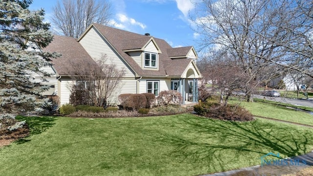 view of front of home with a front lawn and a shingled roof