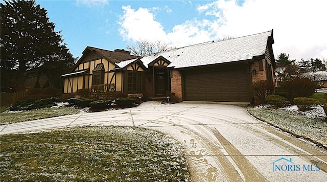 view of front facade featuring a garage, driveway, brick siding, and a shingled roof