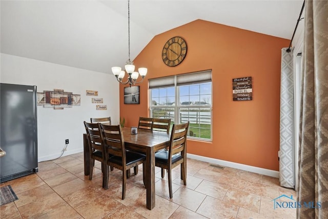 dining room featuring vaulted ceiling, a chandelier, visible vents, and baseboards