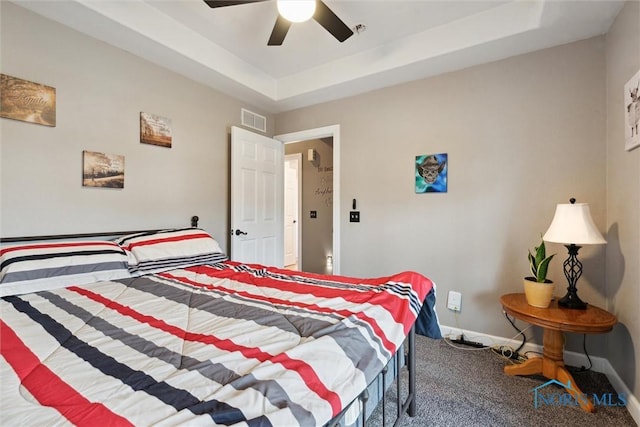 bedroom featuring baseboards, visible vents, a raised ceiling, a ceiling fan, and carpet floors