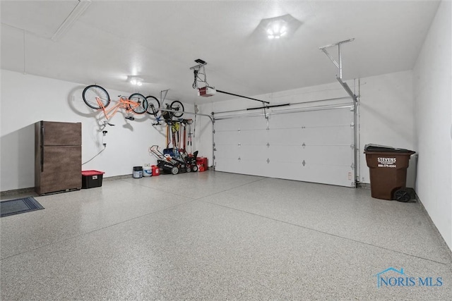 garage with a garage door opener and freestanding refrigerator