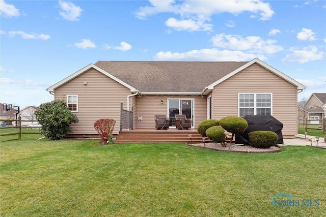 rear view of property with a yard and a deck