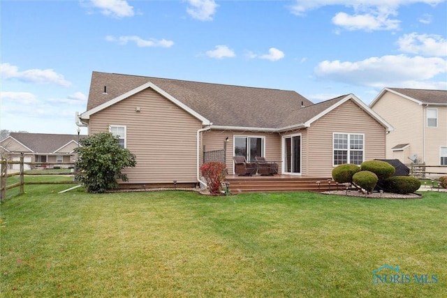 back of house with a lawn, fence, and a wooden deck