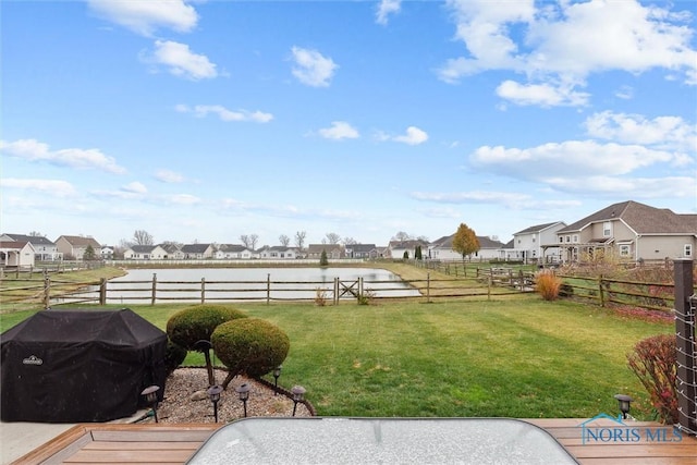 view of yard with a water view, a residential view, and fence