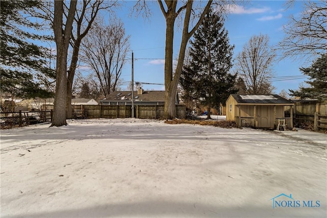 yard covered in snow featuring fence