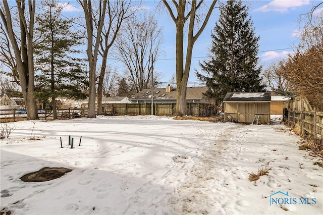 yard covered in snow with a fenced backyard