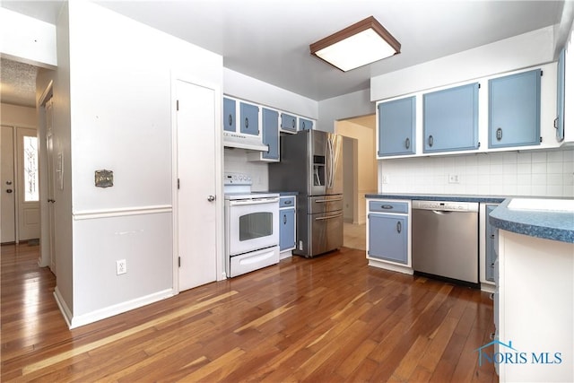 kitchen with blue cabinetry, under cabinet range hood, stainless steel appliances, and dark wood-style flooring