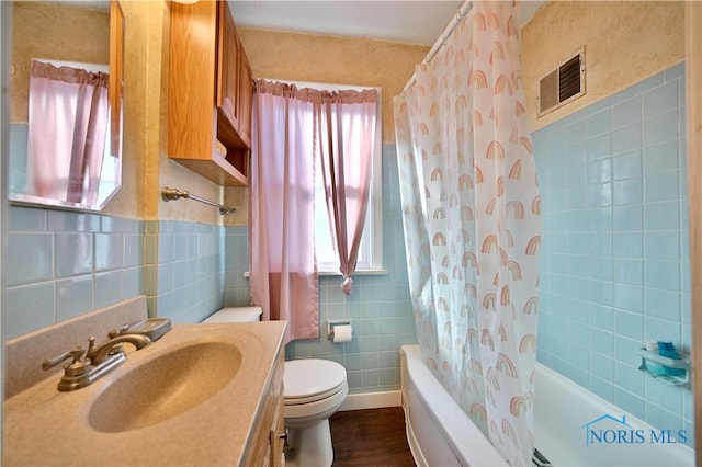 full bathroom featuring shower / bath combo, visible vents, tile walls, and toilet