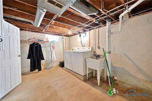 basement featuring independent washer and dryer and a sink