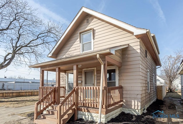 view of front facade with covered porch and fence