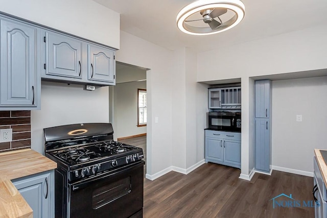 kitchen featuring black appliances, butcher block counters, dark wood finished floors, and baseboards