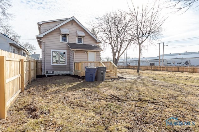 rear view of house featuring a fenced backyard