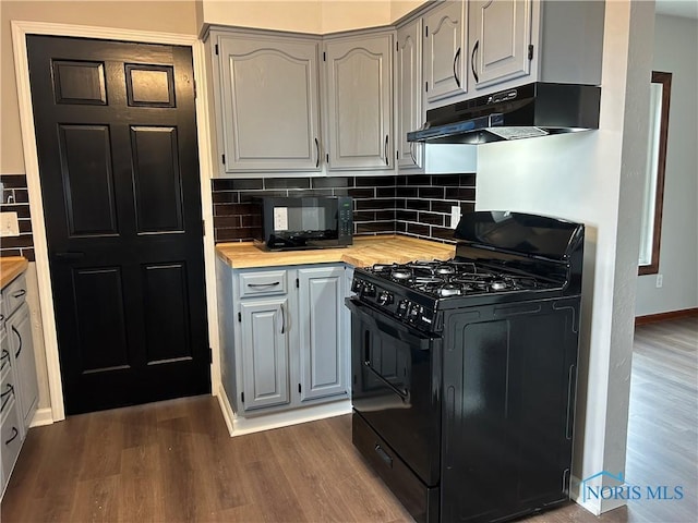 kitchen featuring black appliances, butcher block counters, under cabinet range hood, and dark wood-style floors