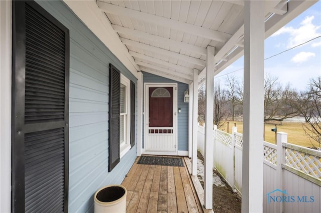 property entrance with fence and a porch