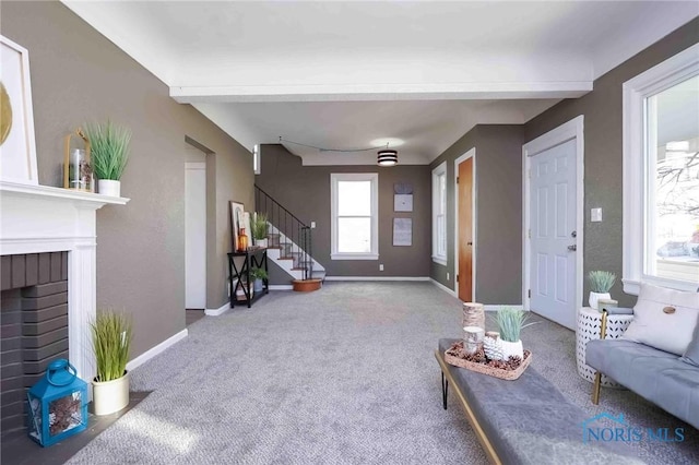 carpeted living room featuring stairway, a fireplace, and baseboards