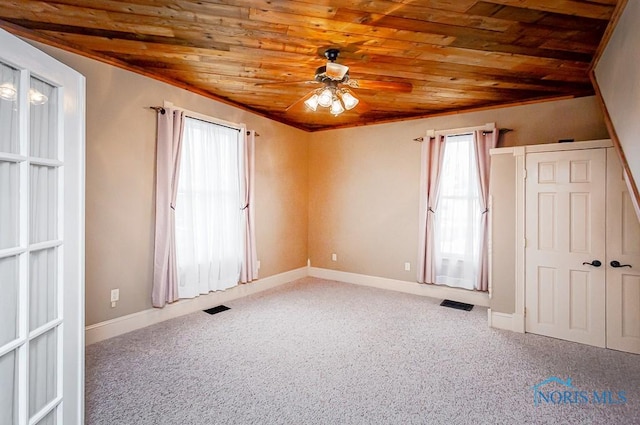 carpeted empty room featuring ceiling fan, wooden ceiling, visible vents, and baseboards