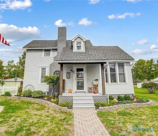 view of front of home featuring a shingled roof, a chimney, fence, and a front lawn