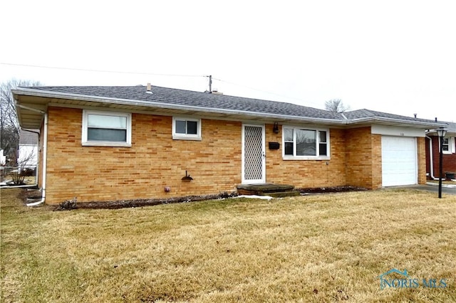 view of front of property with a garage, a front yard, brick siding, and a shingled roof