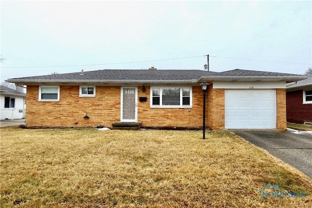 single story home featuring driveway, roof with shingles, an attached garage, a front yard, and brick siding