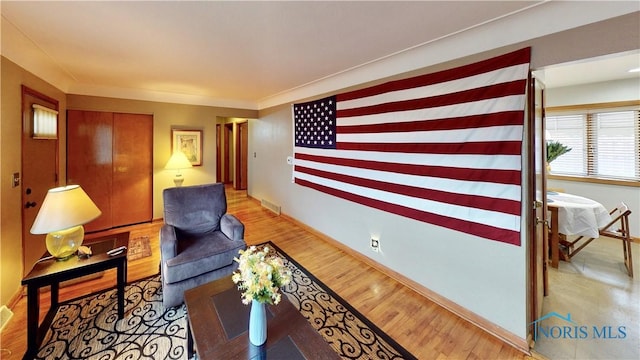 living area with visible vents and wood finished floors