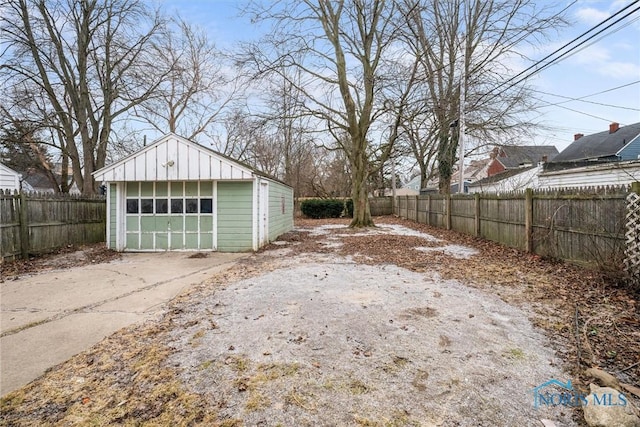 detached garage with fence and driveway