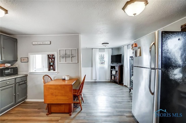 dining area featuring a textured ceiling, a wealth of natural light, and wood finished floors