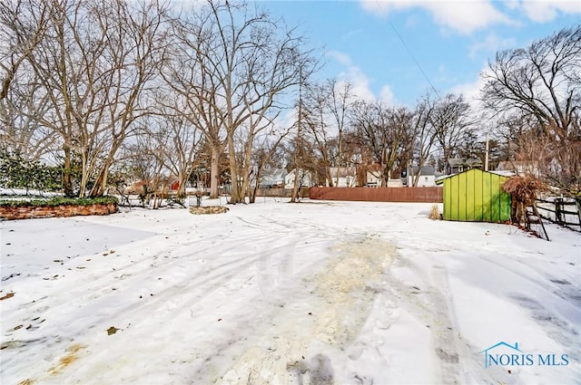 yard layered in snow with fence