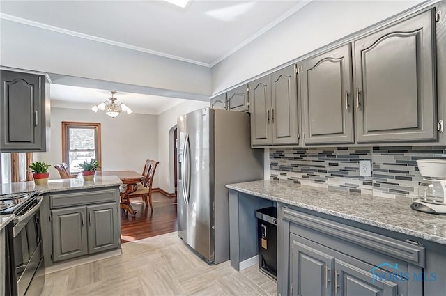 kitchen featuring tasteful backsplash, appliances with stainless steel finishes, light stone counters, and gray cabinetry