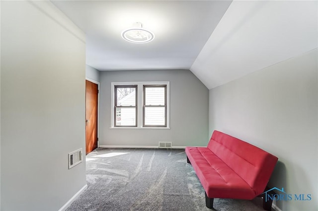 living area with carpet floors, baseboards, visible vents, and vaulted ceiling