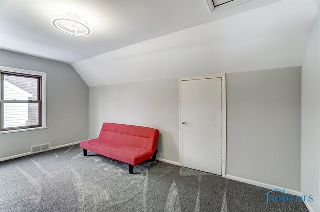 unfurnished room featuring vaulted ceiling, dark carpet, visible vents, and baseboards