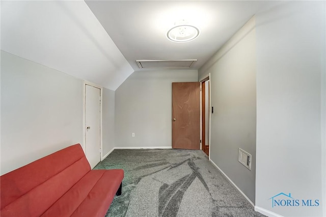 living area with carpet flooring, visible vents, baseboards, vaulted ceiling, and attic access