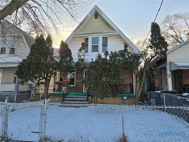 view of front of property featuring brick siding and a fenced front yard