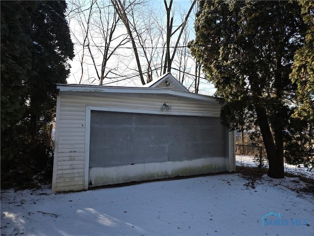 snow covered garage featuring a garage