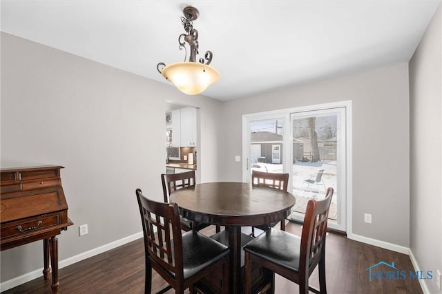 dining space with baseboards and dark wood-type flooring