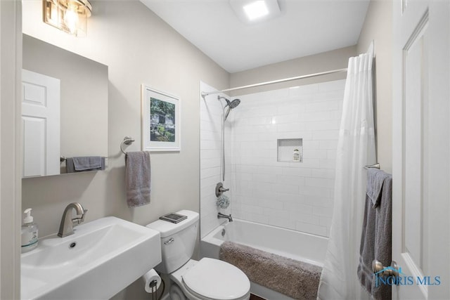 full bath featuring shower / tub combo with curtain, a sink, and toilet