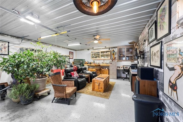 living area featuring a ceiling fan and speckled floor