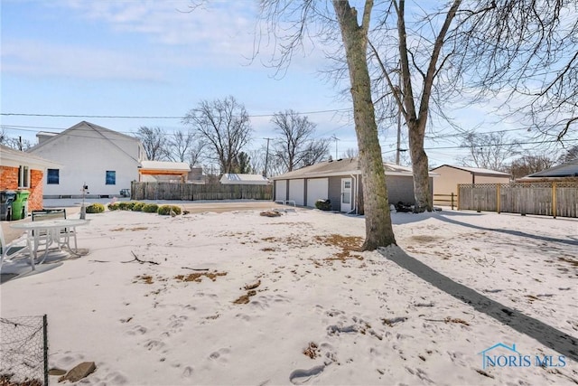 view of yard featuring a detached garage, fence, and an outdoor structure