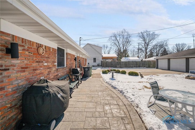 view of patio / terrace featuring grilling area, fence, and an outdoor structure