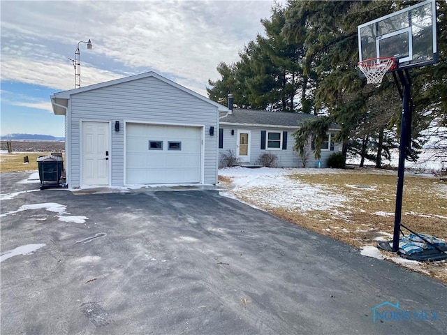 single story home featuring an attached garage and aphalt driveway