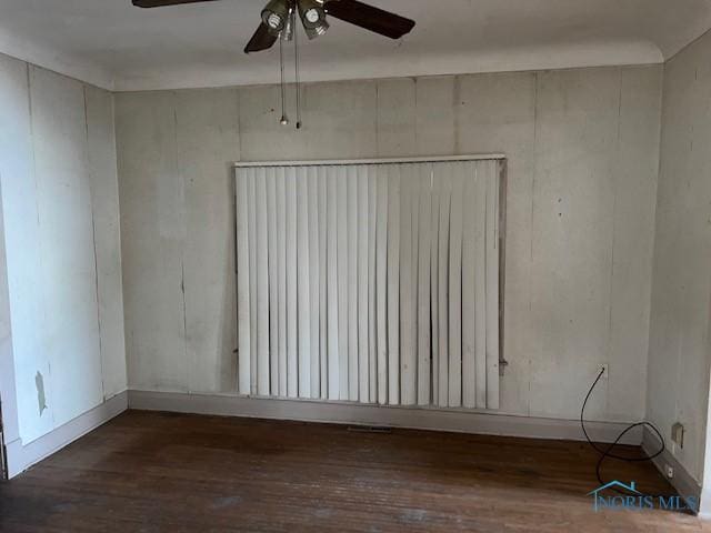 empty room featuring dark wood-type flooring, radiator heating unit, and a ceiling fan