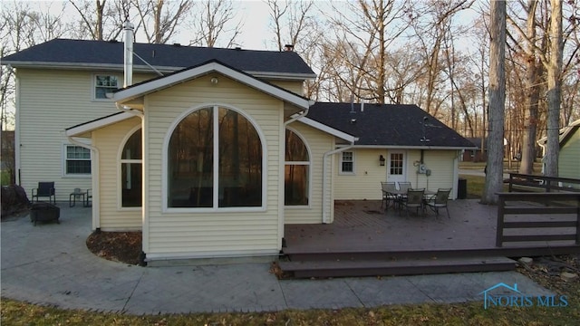 back of property featuring a deck and outdoor dining area